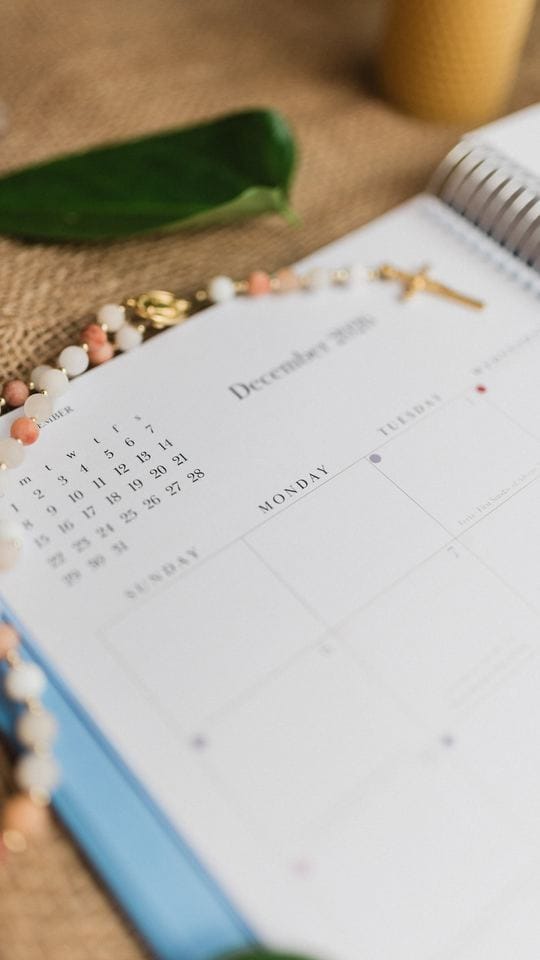 The December 2026 monthly spread with a rosary laid across it