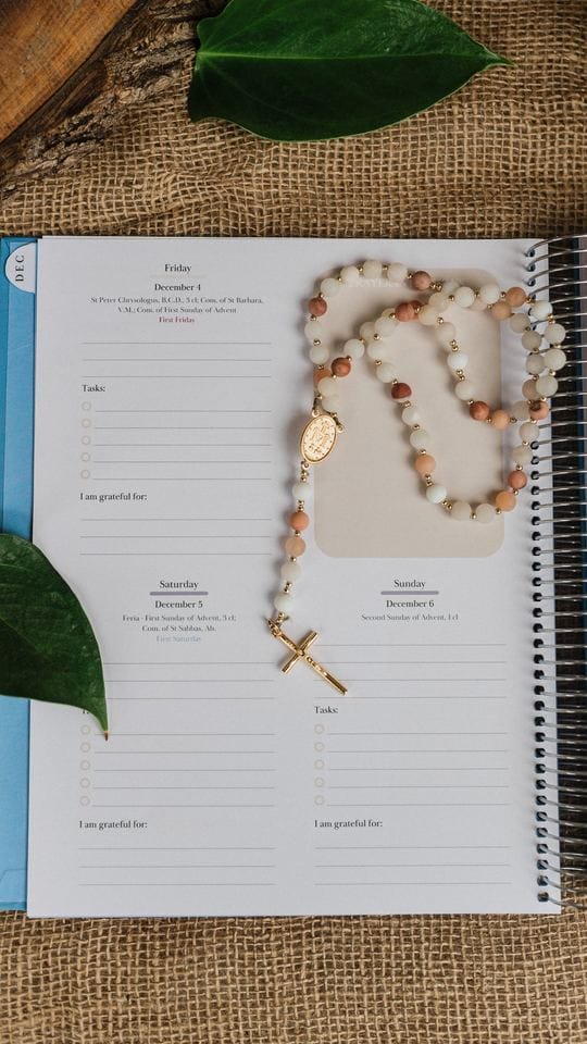 A weekly page with a rosary laid across it