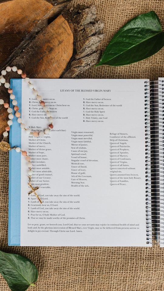 The planner open to the litany pages, with a rosary